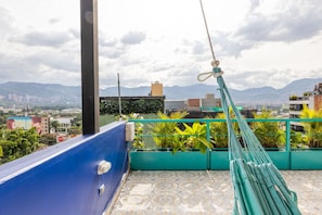 Eine Dachterrasse mit Blick auf Stadt und Berge.