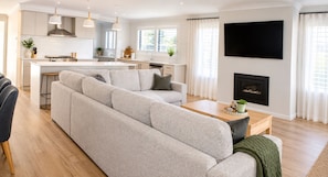 A modern living room with a sectional sofa, a coffee table, and a fireplace. - Silverwoods Retreat I Lake Mulwala & Golf - Your perfect Yarrawonga getaway! (Yarrawonga)