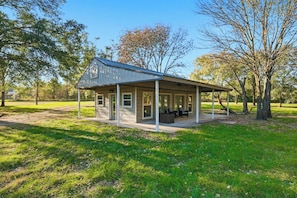 A small, single-story building with a covered porch and a patio area.