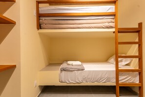 Kerrossänky, jossa on tikkaat, alhaalla yksi normaali sänky ja seinässä pistorasia.