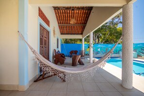 A hammock under a wooden ceiling, a pool, and a mural with marine life. - House with a pool 350 m from Peroba Beach (Maragogi)