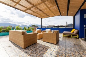 A rooftop patio with wicker furniture, a patterned floor, and a view of the cityscape. - Utop a 3 West Elegant 2BR Wi-fi AC Self Check-in (Medellín)