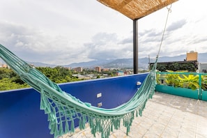 A hammock on a blue balcony with a cityscape view. - Utop a 1 East-calm Loft Optical Fiber Selfcheckin (Medellín)