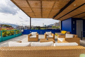 A rooftop terrace with wicker furniture and a view of the city. - Utop a 1 East-calm Loft Optical Fiber Selfcheckin (Medellín)