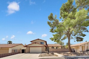 A residential area with houses, a large tree, and a clear sky. - Travelers Dream|Monthly Stays|Strip in the Horizon (Las Vegas)
