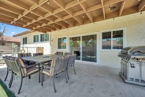 An outdoor patio with a dining table and chairs, a barbecue grill, and a covered area with a wooden ceiling. - Travelers Dream|Monthly Stays|Strip in the Horizon (Las Vegas)