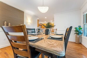 A dining area with a wooden table, chairs, and a hanging light fixture. - Peaceful Luxury Retreat Short Drive to Columbia (Lexington)