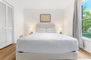 A bedroom with a large bed, two bedside tables with lamps, a framed picture on the wall, and a window with curtains. - Peaceful Luxury Retreat Short Drive to Columbia (Lexington)