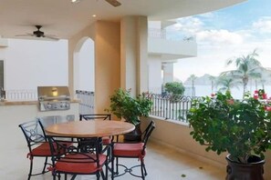 An outdoor patio with a round table and chairs, a grill, and potted plants. - Estancia on Medano Beach! Ideal location, close to beach-end! (Cabo San Lucas)