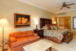 Ein Hotelzimmer mit Bett, Sofa, Tisch und einem Bild an der Wand.