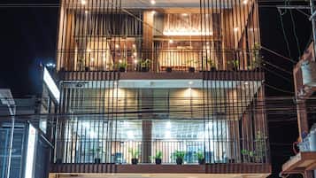 Un edificio de varios pisos con balcones, ventanas amplias y cableado eléctrico visible.