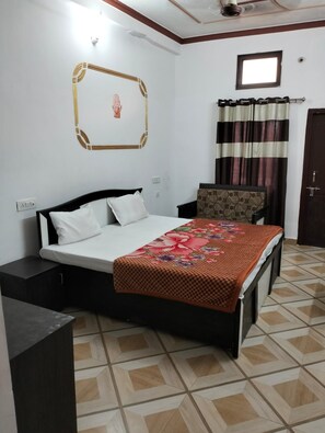 Quarto com cama, cadeira, guarda-roupa, janela com cortinas e decoração na parede.