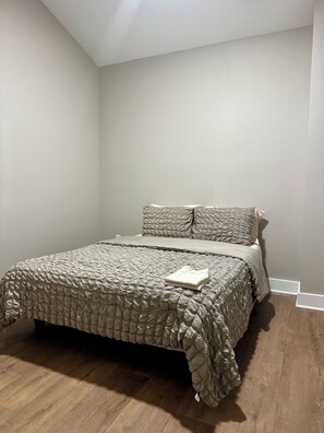 A bedroom with a bed, pillows, and a folded blanket. - Modern & Beautiful Home Near the Airport (Charlotte)