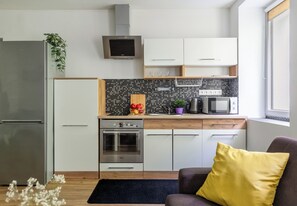 A modern kitchen with a built-in oven, microwave, and a stainless steel refrigerator. - Piłsudskiego City Center Apartment (Szczecin)