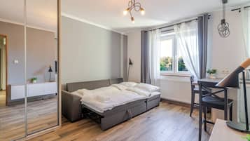 Un dormitorio moderno con cama, mesita de noche y un espacio de escritorio.