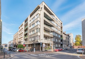 A multi-story building with a parking lot in front.