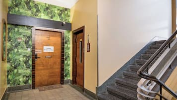 A hallway with a wooden door labeled 'Hostel Moderna-Rest' and a staircase with a metal handrail.