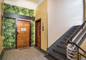 A hallway with a wooden door labeled 'Hostel Moderna-Rest' and a staircase with a metal handrail.