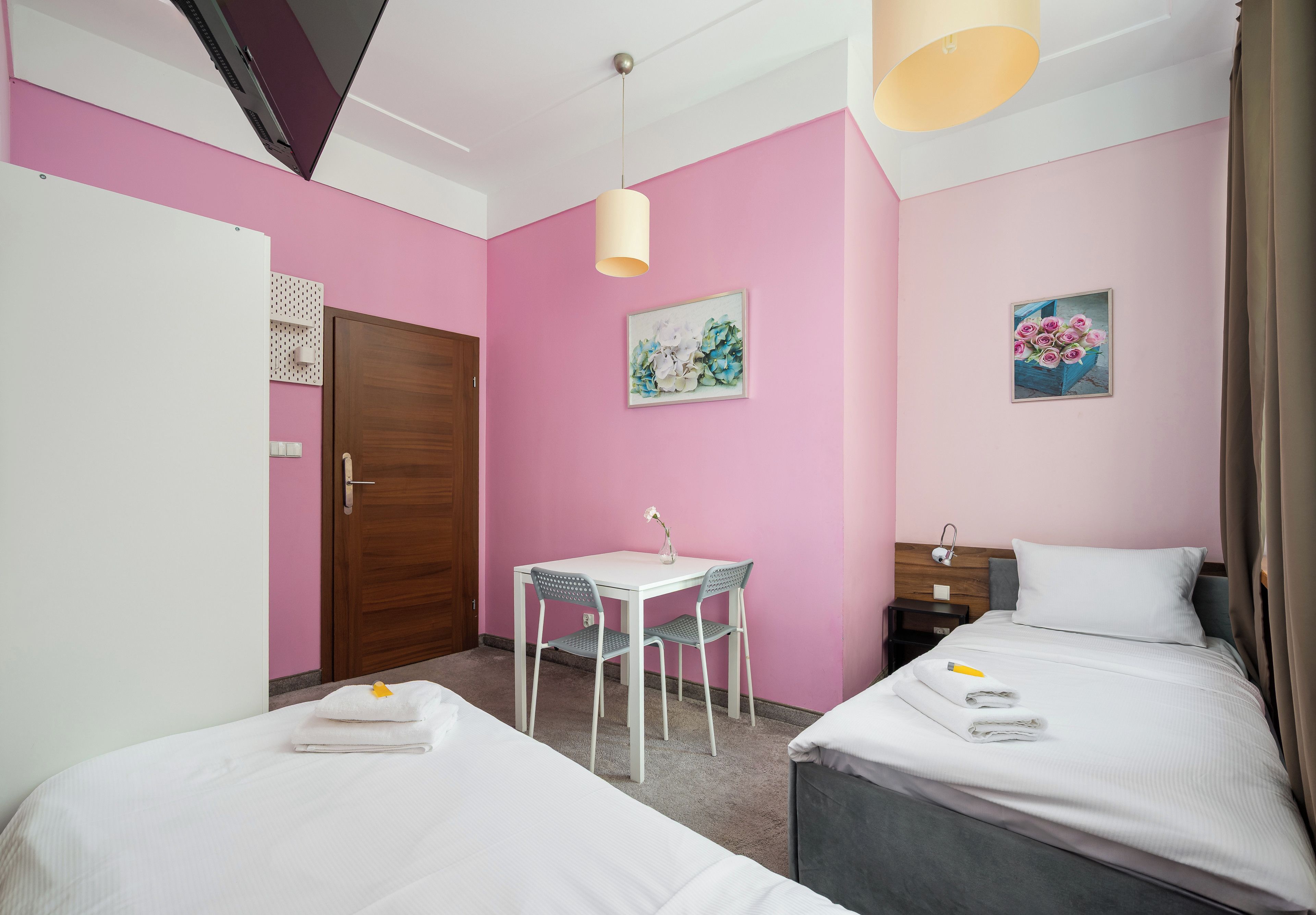 Une chambre avec deux lits, un bureau et des chaises.