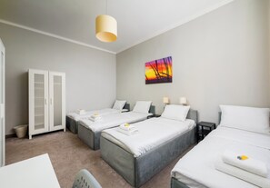 A hotel room with two beds, a wardrobe, a painting, and a hanging light fixture. - Hostel Moderna Rest Room 6 (Katowice)