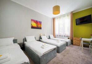 A hotel room with two beds, a desk, a TV, and a painting on the wall. - Hostel Moderna Rest Room 6 (Katowice)