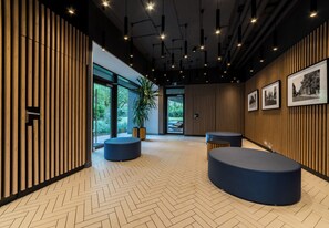 Ein modernes Interieur mit Holzvertäfelung, Fischgrätparkett und Pendelleuchten.