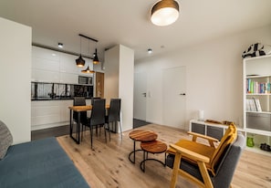 Un espace de vie moderne comprenant un coin repas, une cuisine et une bibliothèque.