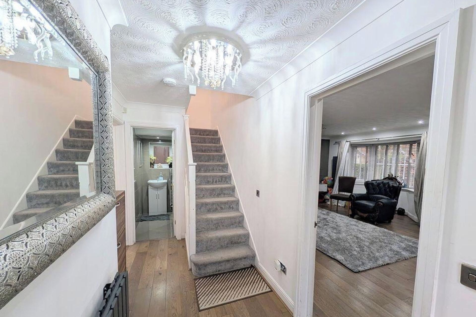 A staircase leading to a bathroom with a sink and mirror.