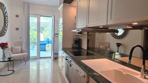 Una cocina moderna con una isla grande, horno empotrado y un amplio ventanal.