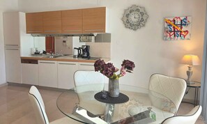 A modern kitchen with white cabinets, a coffee maker, and a clock on the wall. - Holiday Apartment No. 2 Tranquility (Baška)