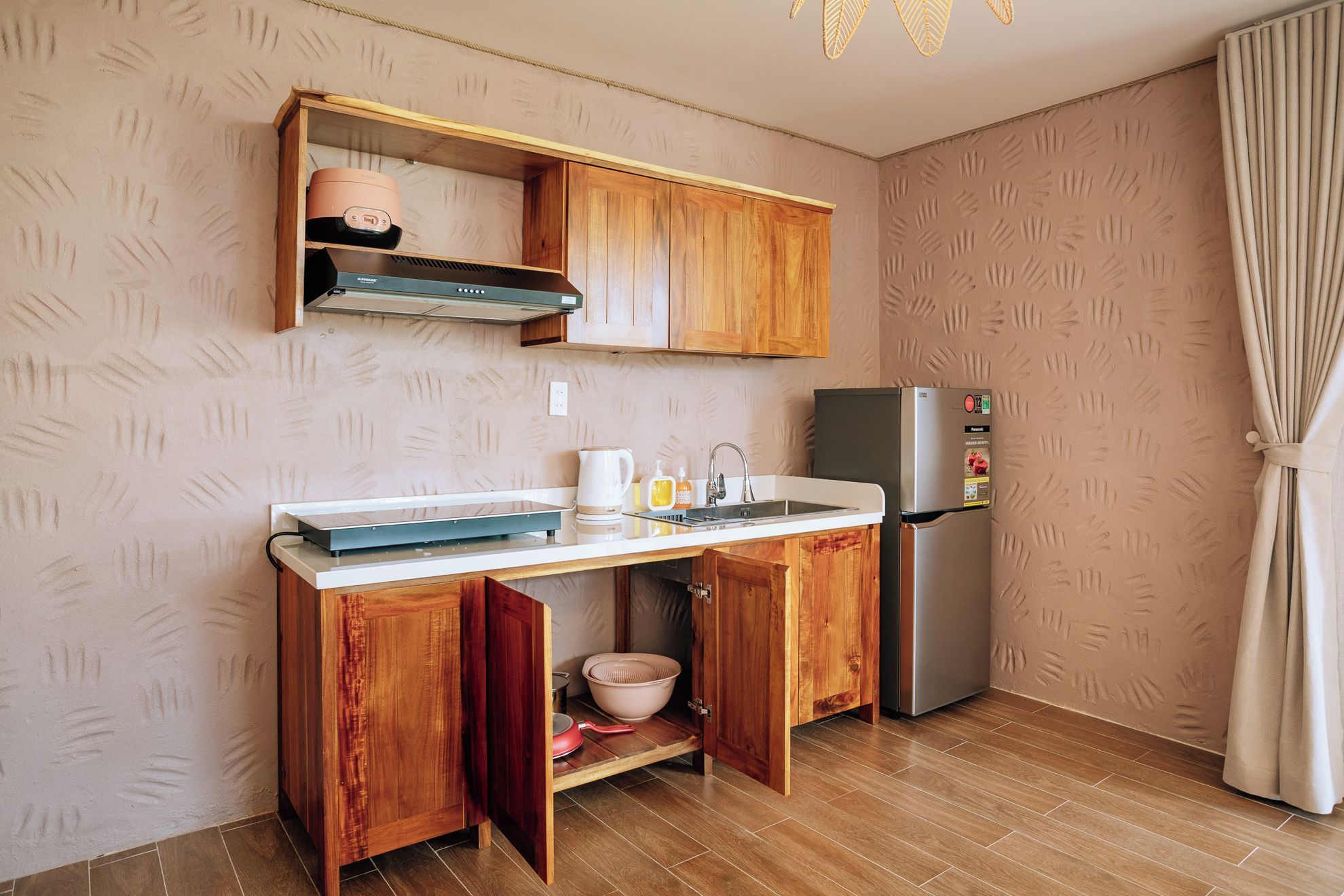 A compact kitchen with wooden cabinets, a built-in oven, and a refrigerator.