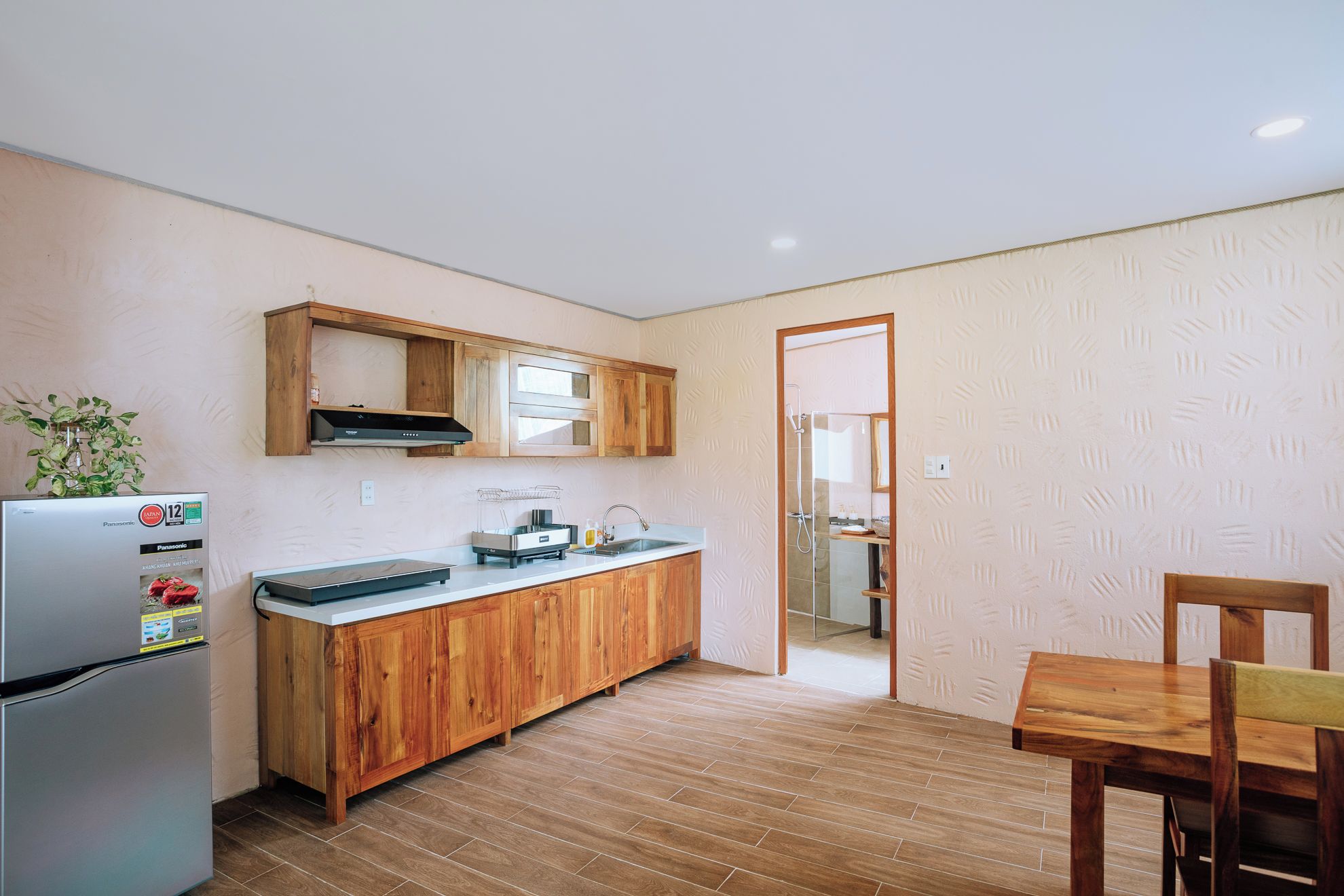 A compact kitchen with wooden cabinets, a built-in oven, and a refrigerator.
