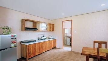 A compact kitchen with wooden cabinets, a built-in oven, and a refrigerator.
