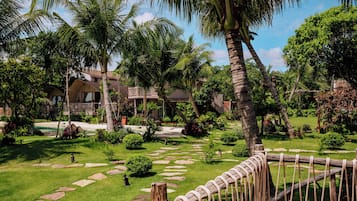 Un resort tropical con piscina, palmeras y una valla de madera.
