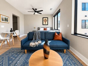 A modern living room with a sofa, a coffee table, and a vase. - Sleepover | Dashing Studio + Gym/Sauna + Omaha (Omaha)