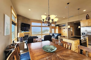 A modern kitchen with a dining area, large windows, and a fireplace. - Luxurious Home Sits Right on the Beach! Pet Friendly! (Waldport)