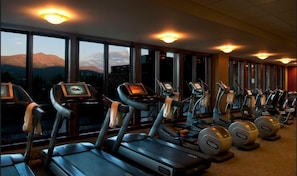 A gym with treadmills and elliptical machines, large windows with a mountain view, and a carpeted floor. - Grand Lodge Peak 7-Ski-In Ski-Out Breck Condo, Mtn Views, Resort Amenities, Sleeps 16 (Breckenridge)