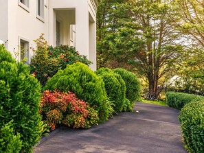 A well-maintained driveway leading to a white building with a covered porch. - Warrandyte Bush Retreat  6BR with Private Pool (Warrandyte)