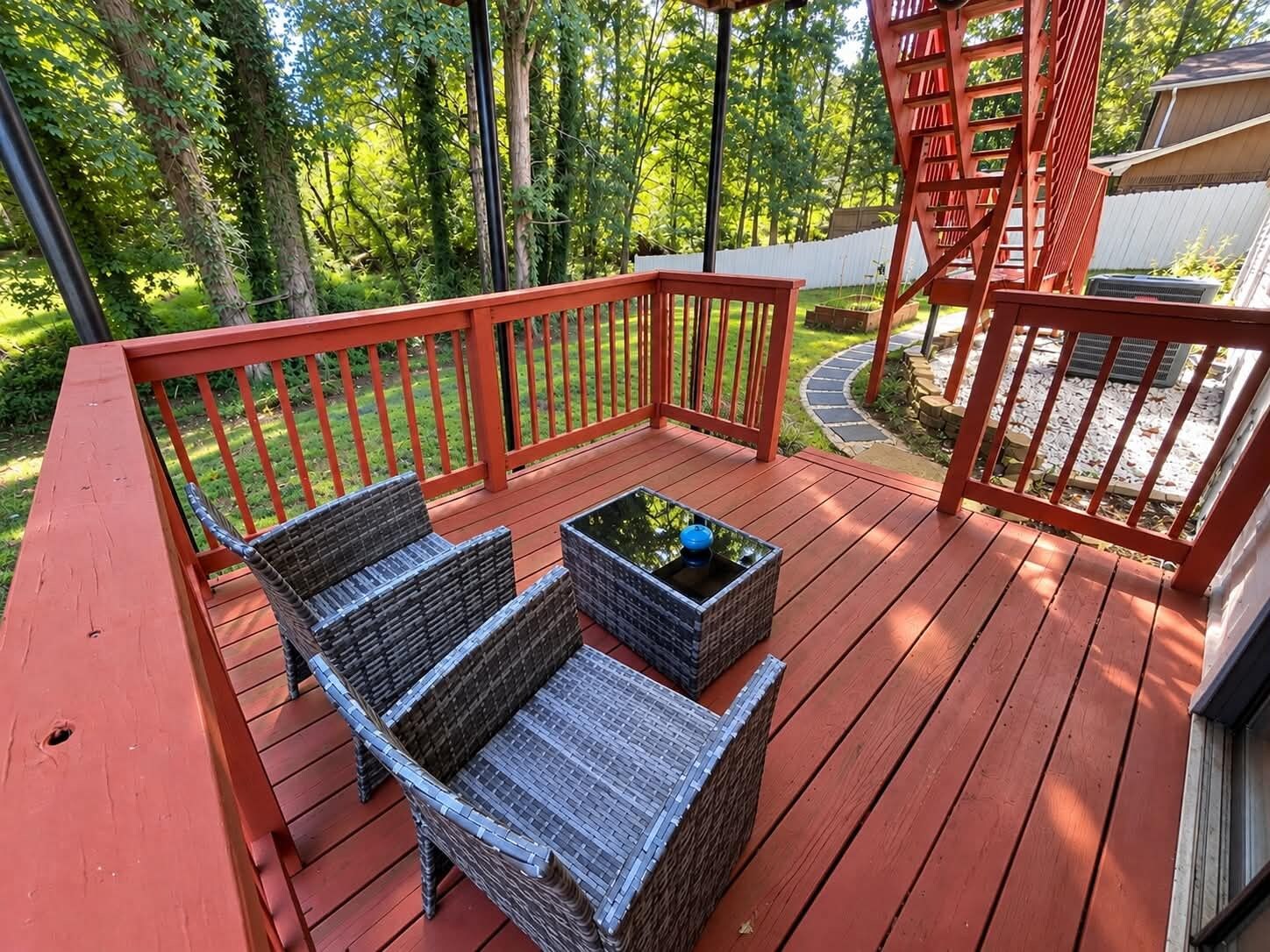 A wooden deck with wicker furniture and a small table.