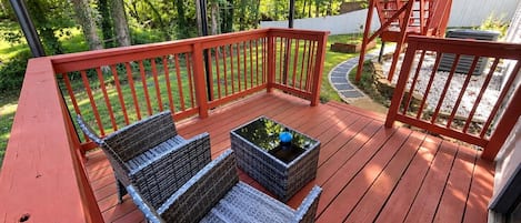 A wooden deck with wicker furniture and a small table.
