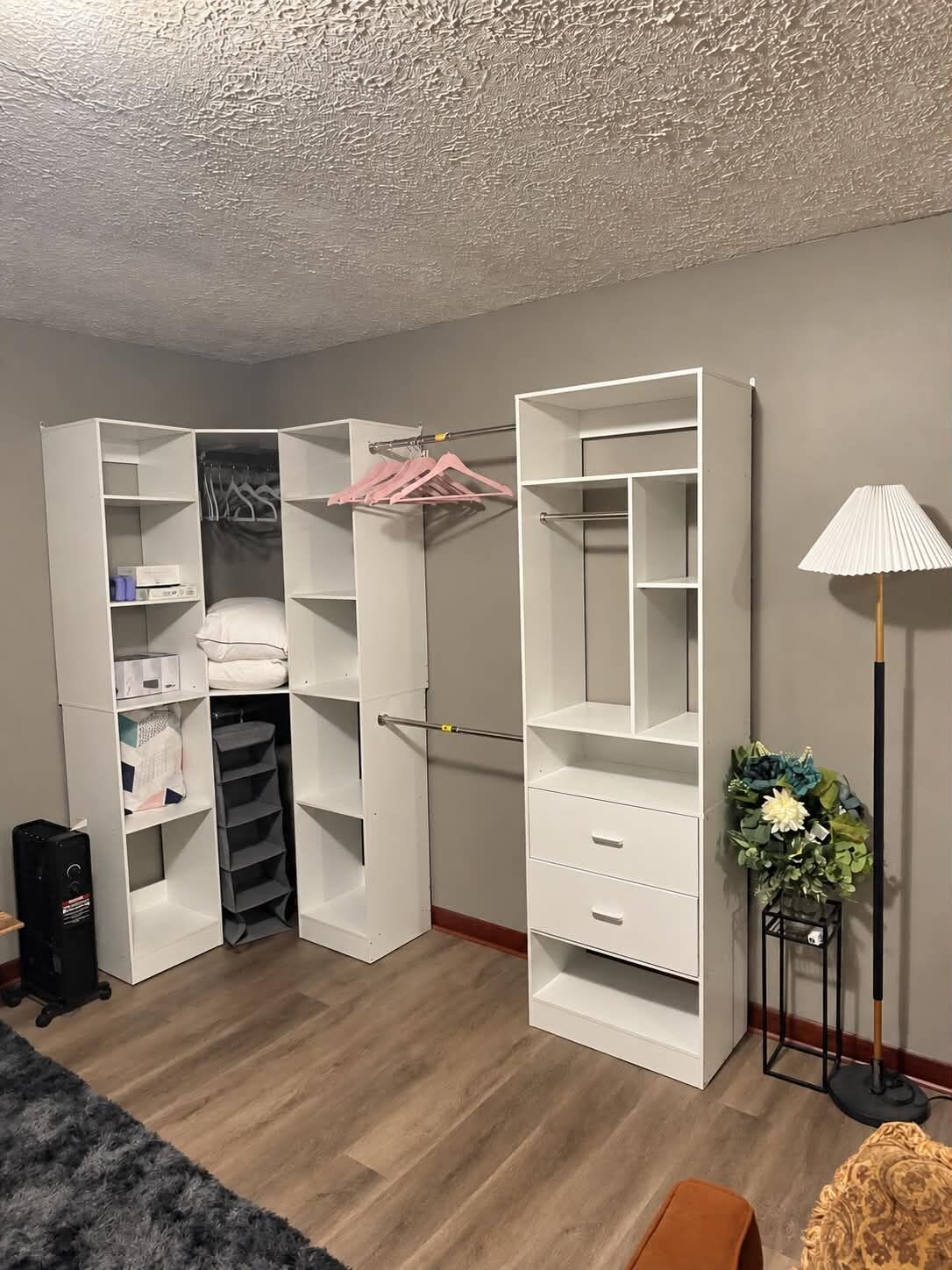 A walk-in closet with open shelves, hanging space, and a mirror.