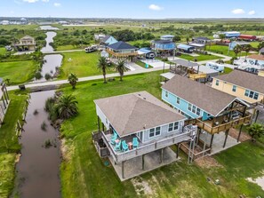 A residential area with houses, a small waterway, and a clear sky. - 5 Minute Walk To Beach (Bolivar Peninsula)