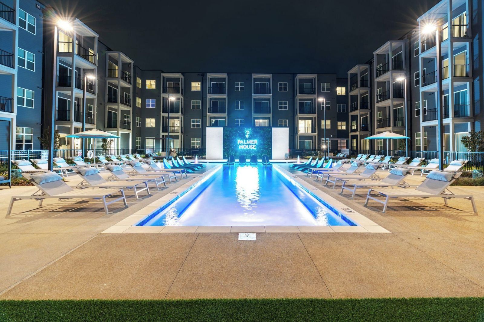 A hotel pool area with lounge chairs and a sign reading 'PALMER HOUSE.'