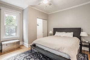 A bedroom with a bed, bedside lamps, a window, and a door. - This NEW "Old" House• Broad Ripple Home Steps From Dining, Nightlife & The Monon (Indianapolis)