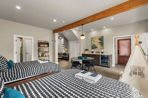 Een moderne slaapkamer met een groot bed, een bureau en een kitchenette.