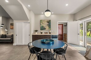 Een moderne keuken met een rond blauw tafel, witte kastjes en een hanglamp.