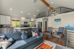 A modern kitchen with white cabinets, a central island, and a stainless steel refrigerator. - Turkey Trot Lodge | Private Hot Tub, 2 Miles to Downtown Leavenworth (Leavenworth)