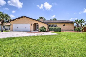 A single-story house with a garage, a front lawn, and a clear sky. - 2 Mi to Beach! Pool, Hot Tub, 2 Tiki Bars, Pets OK (Bonita Springs)