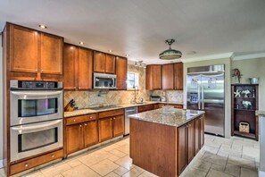A kitchen with wooden cabinets, stainless steel appliances, and a granite countertop. - Haze Estate: Weddings, Events, Pool, Lake & Bar (Bonita Springs)