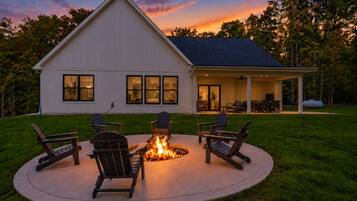 A house with a covered patio area featuring a fire pit and outdoor seating.